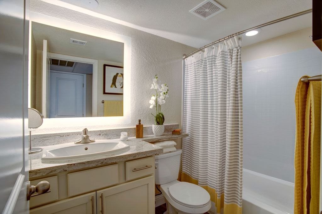 A bathroom with a sink, toilet, and shower curtain.